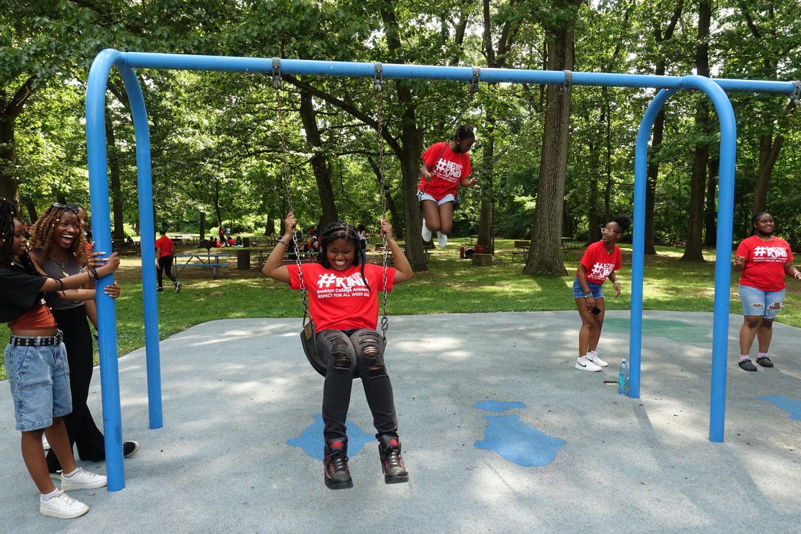Students laughing on playground swings